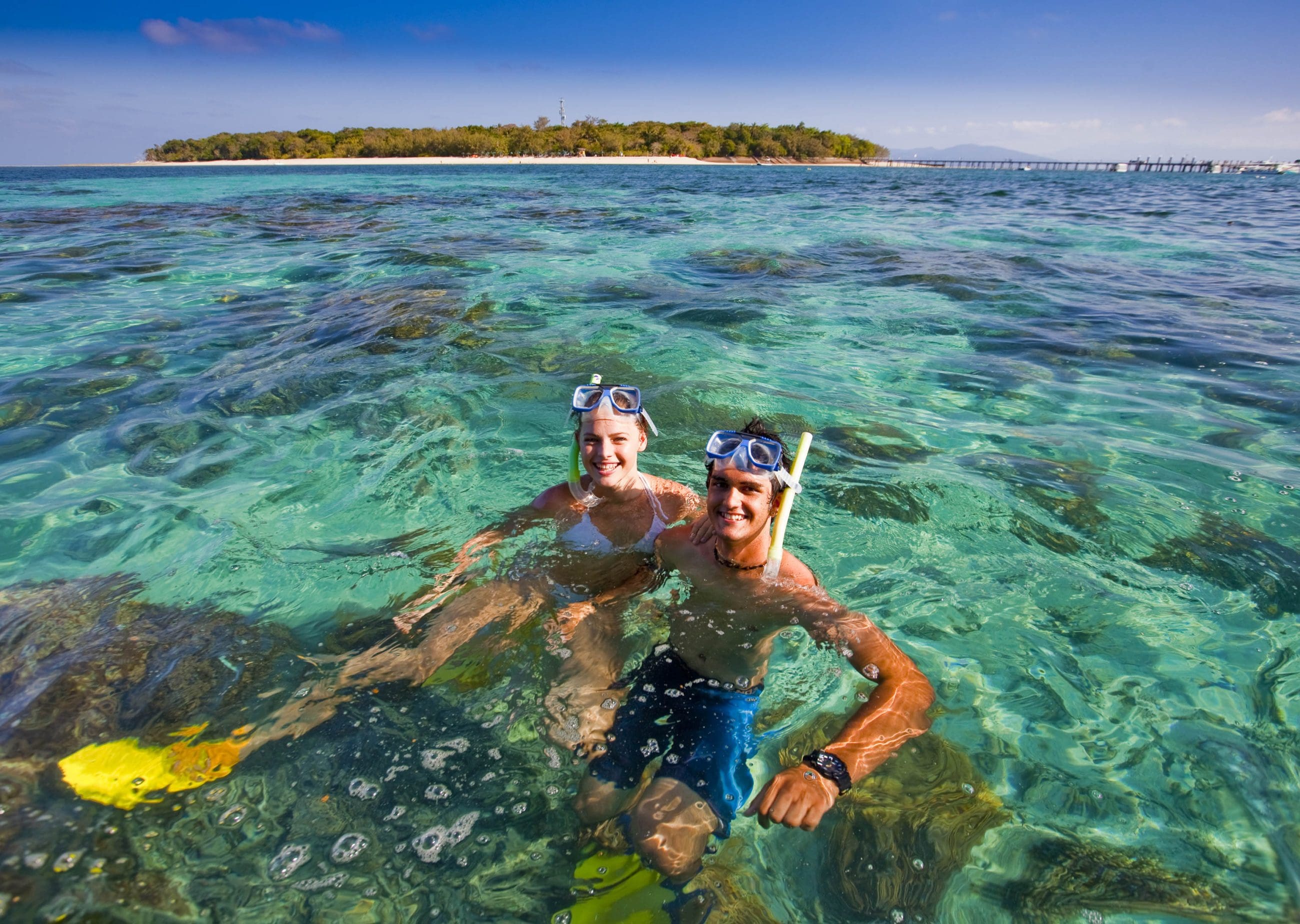 Snorkellers explore crystal-clear waters near lush Green Island on a popular Half-Day Tour, 1pm departure, top-rated tropical adventure.