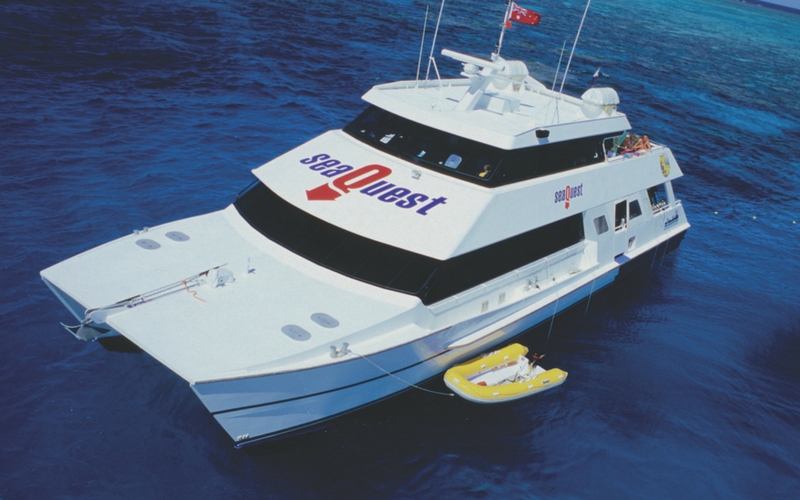 Luxury SeaQuest catamaran yacht anchored on vibrant blue waters during an Outer Reef Day Trip, perfect for snorkelling and adventure seekers.