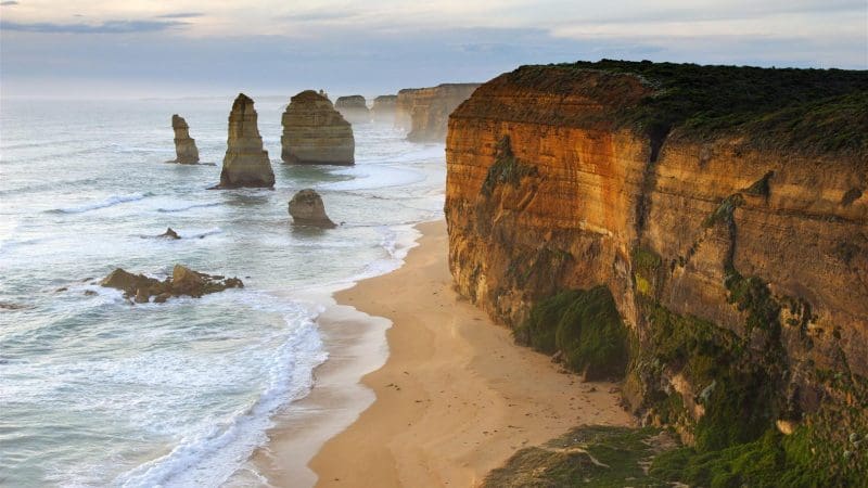Spectacular sunset illuminates the Twelve Apostles’ iconic sea stacks and rugged cliffs on a Go West Tours Great Ocean Road day trip.