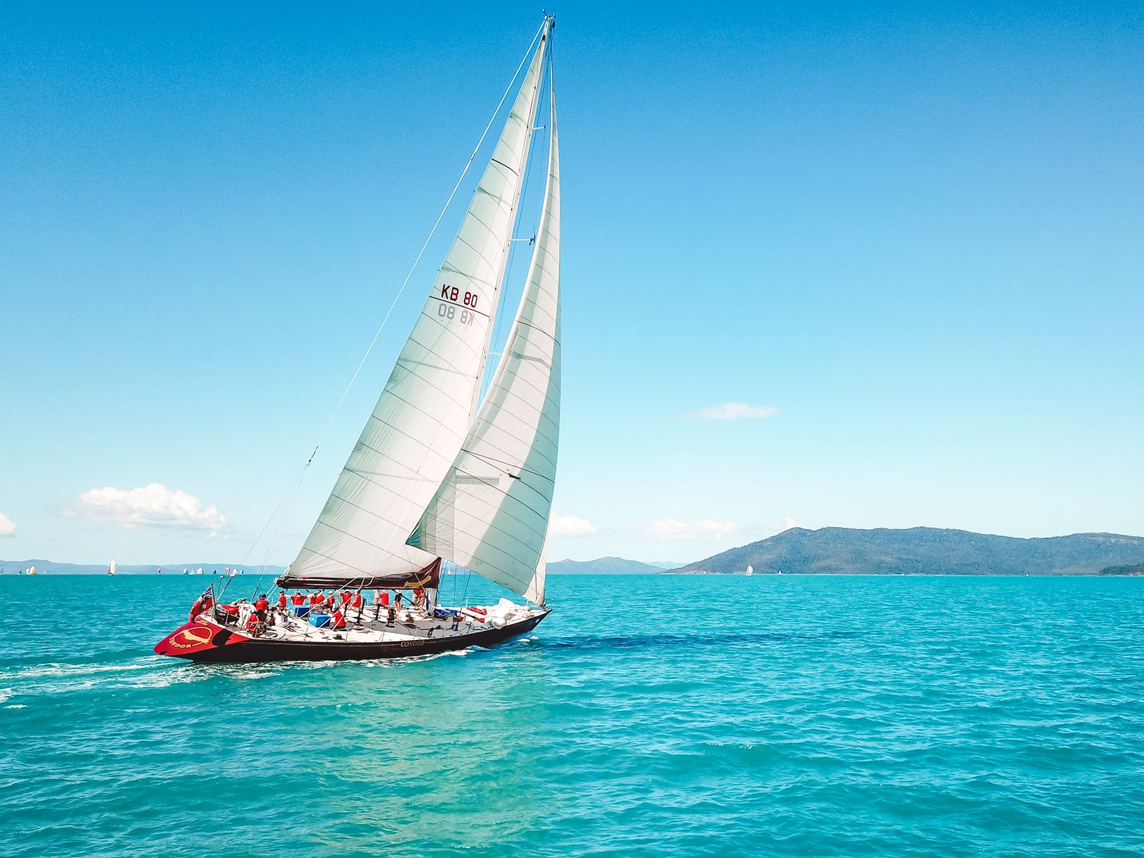 Experience the ultimate 2 Day, 2 Night Condor Whitsunday Sailing adventure gliding over turquoise waters beneath clear skies and scenic hills.