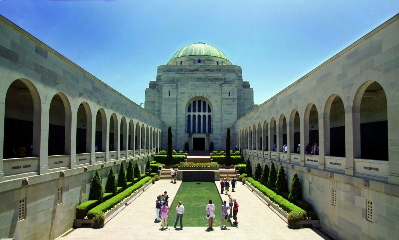 Visitors explore the Australian War Memorial courtyard in Canberra on a Sydney day trip, enjoying sunny skies and iconic scenery.