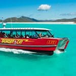 Experience the Thundercat 1 Day Whitsunday Islands Adventure gliding on turquoise waters by pristine white sands and lush green hills.