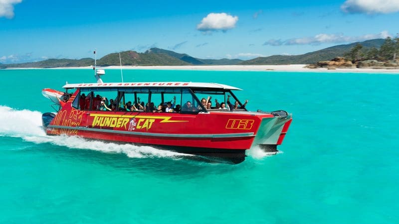 Experience the Thundercat 1 Day Whitsunday Islands Adventure gliding on turquoise waters by pristine white sands and lush green hills.