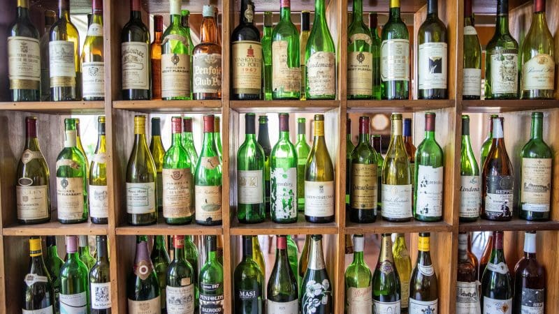 Rows of green and brown empty wine bottles line shelves, evoking memories of a Hunter Valley Scenic Wine Tour experience.