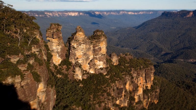 Discover breathtaking views of towering sandstone rock formations above lush forests during a Blue Mountains Sunset Wilderness Tour.