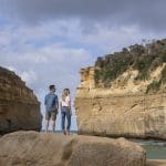 A couple stands atop a scenic rock on a 2 Day Great Ocean Road Grampians Overnight Escape tour departing from Melbourne, Australia.