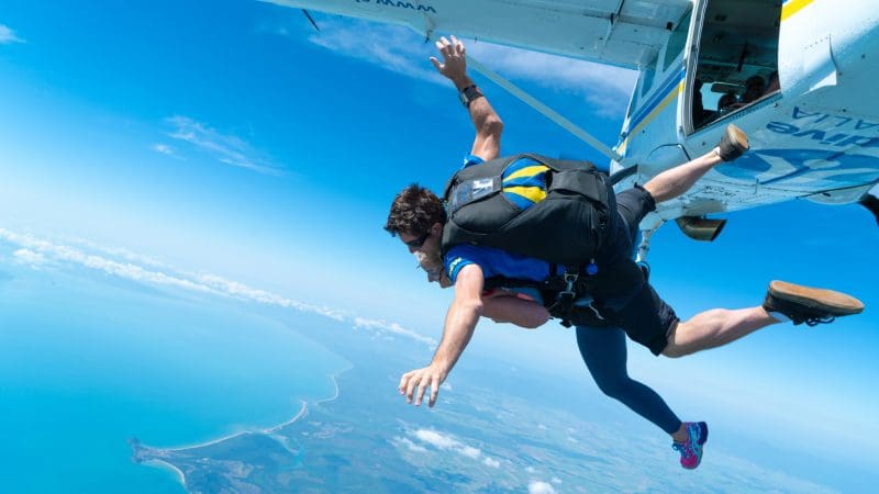Thrill-seekers enjoy a tandem skydive from 15,000ft over Wollongong, soaring above stunning coastline, blue skies, and sea views.