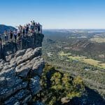 Travellers stand on a rocky lookout, admiring panoramic views along the 3 Day Great Ocean Road Grampians Explorer tour from Melbourne.
