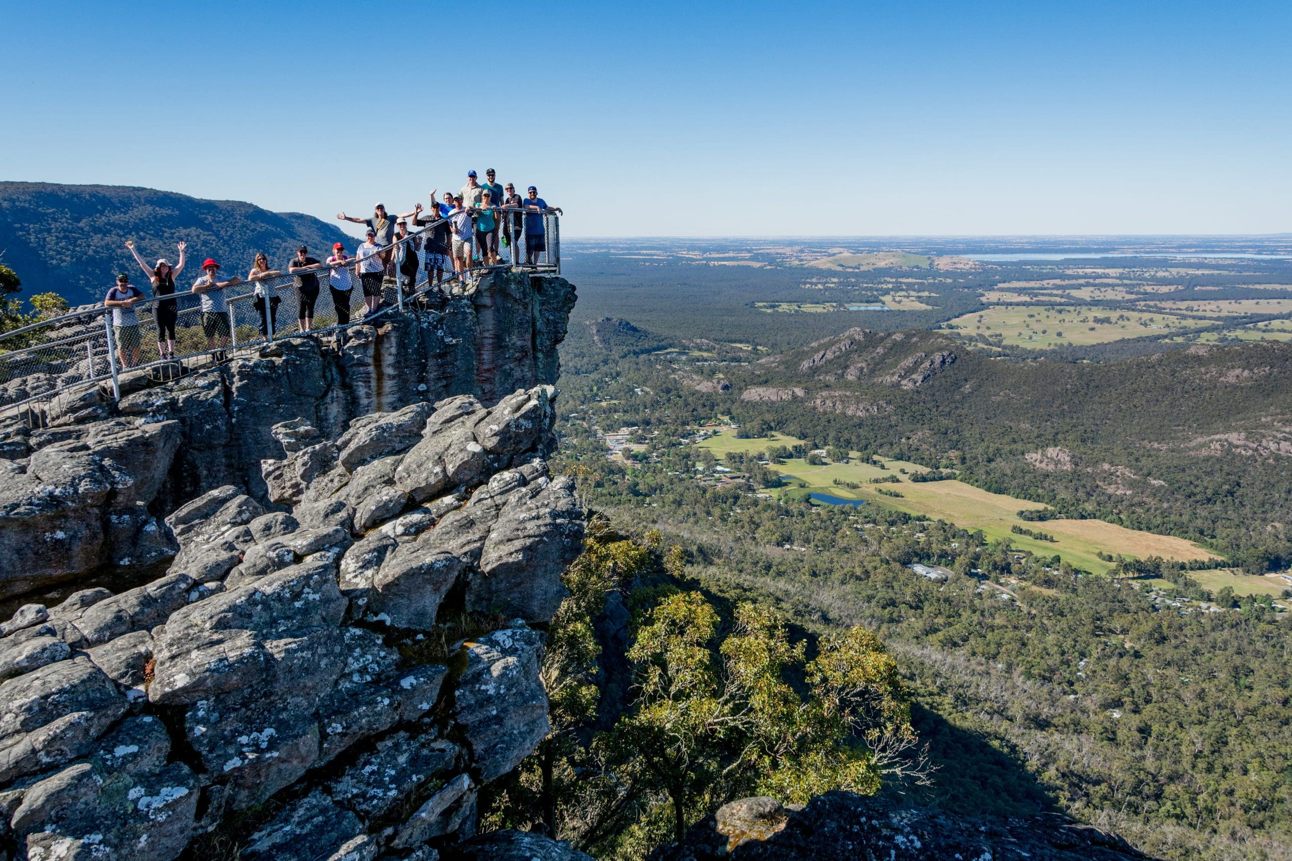 Travellers stand on a rocky lookout, admiring panoramic views along the 3 Day Great Ocean Road Grampians Explorer tour from Melbourne.