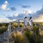 Two women in white spa robes relax at sunset after a 1 Day Peninsula Hot Springs Spa Entry Shuttle Bus experience, serene backdrop.