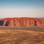 Uluru, the majestic red sandstone monolith, towers over Australia’s outback on the 7 Day Uluru to Adelaide Experience by Untamed Escapes.