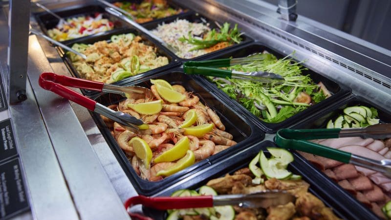 Self-service salad bar with fresh prawns, mixed leaves, and tongs—an ideal pre-tour meal before your Full Day Green Island 11AM departure.