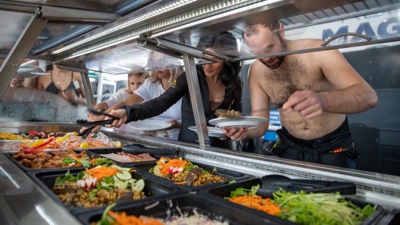 Guests help themselves to a freshly prepared buffet at Reef Magic Outer Barrier Reef Pontoon, enjoying casual seafront dining.