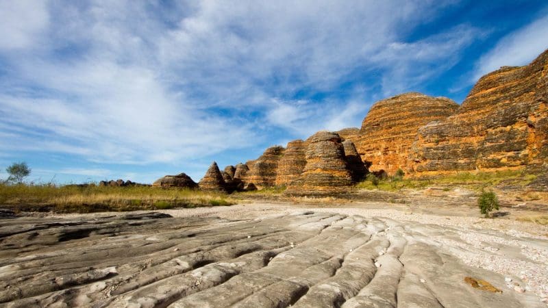 Vivid orange and black striped rock formations beneath a clear blue sky, featured on the popular 10 Day Broome to Darwin Kimberley 4WD Adventure.
