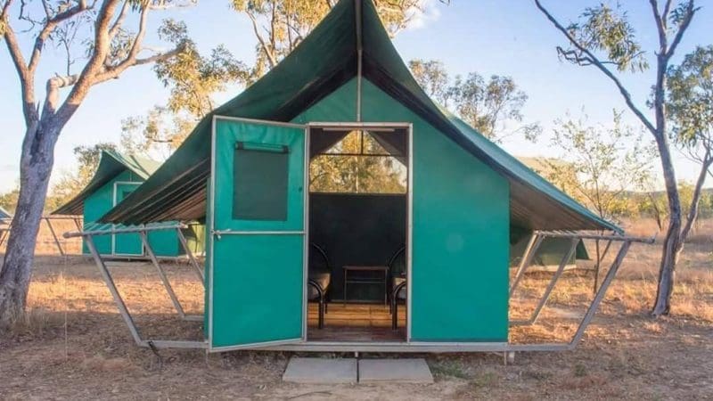 Spacious green tent cabin with open doors in sunlit, dry grassy terrain—ideal base for Kakadu & Litchfield 3 Day 4WD Safari adventure.