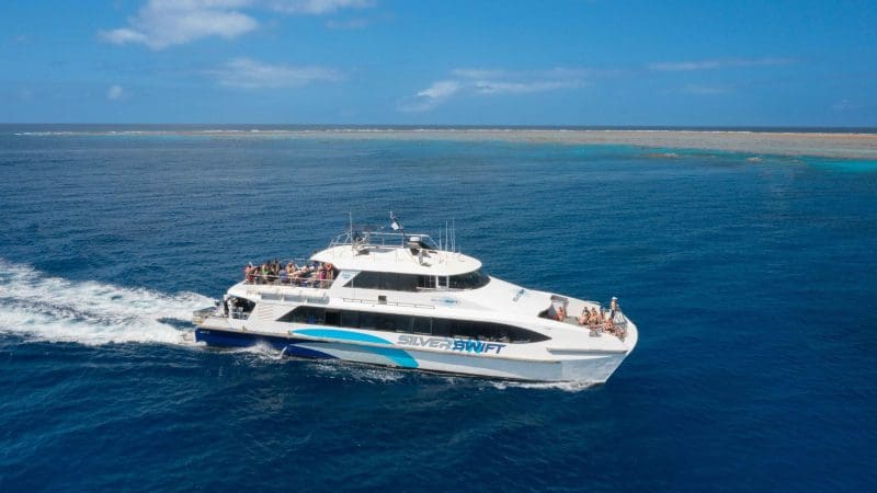 Silverswift catamaran cruises the crystal-clear blue waters on an Outer Barrier Reef snorkel and dive adventure near Cairns, Australia.