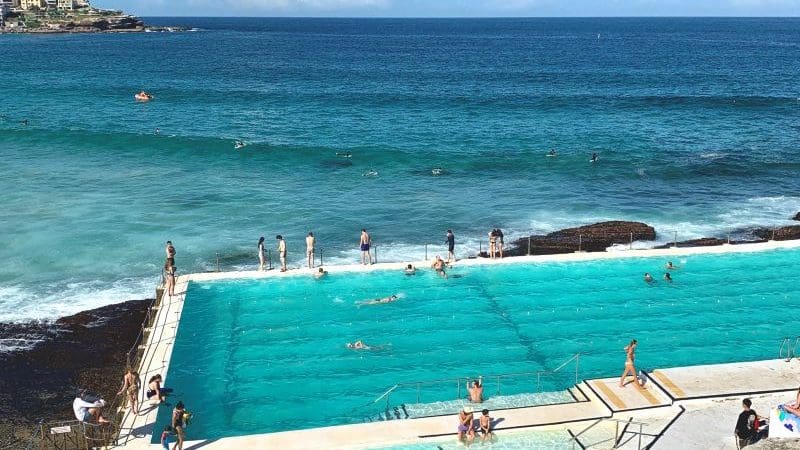 Travellers relax in stunning seafront pools overlooking crystal-clear blue seas and sunny skies, soaking up the Ultimateoz Gap Year adventure.