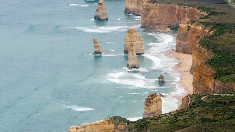 Breathtaking aerial view of the Twelve Apostles, iconic limestone stacks, ocean waves, and dramatic cliffs on Great Ocean Road tour.