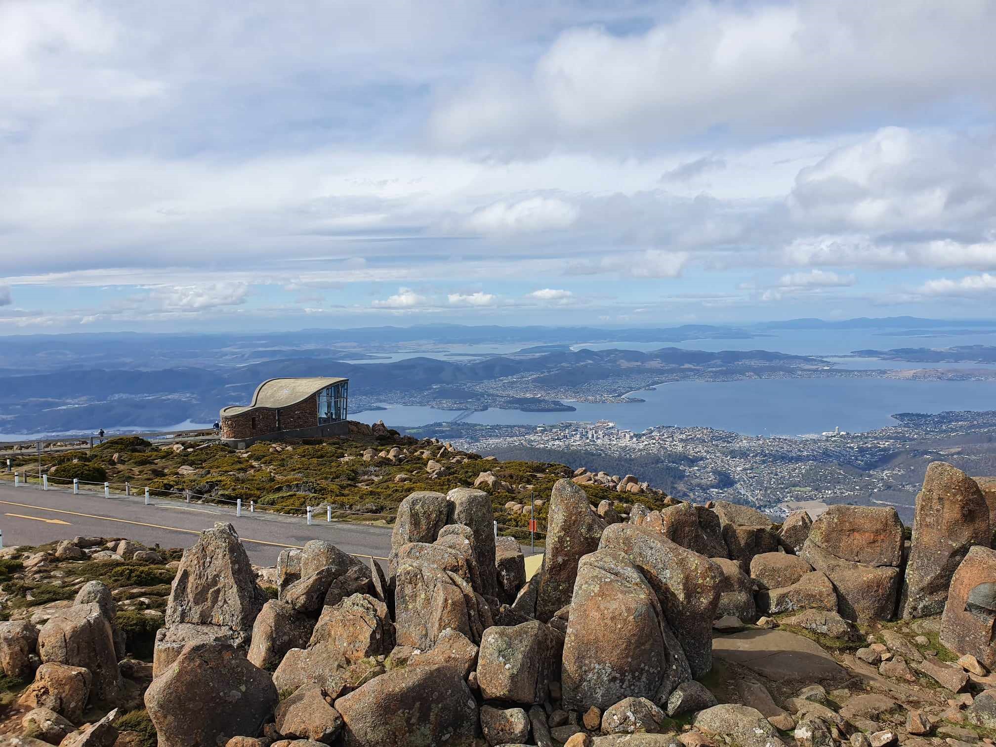 Majestic rocky summit featuring a small building, offering panoramic city views on a Mt Wellington Pinnacle 2 Hour Small Group Tour.