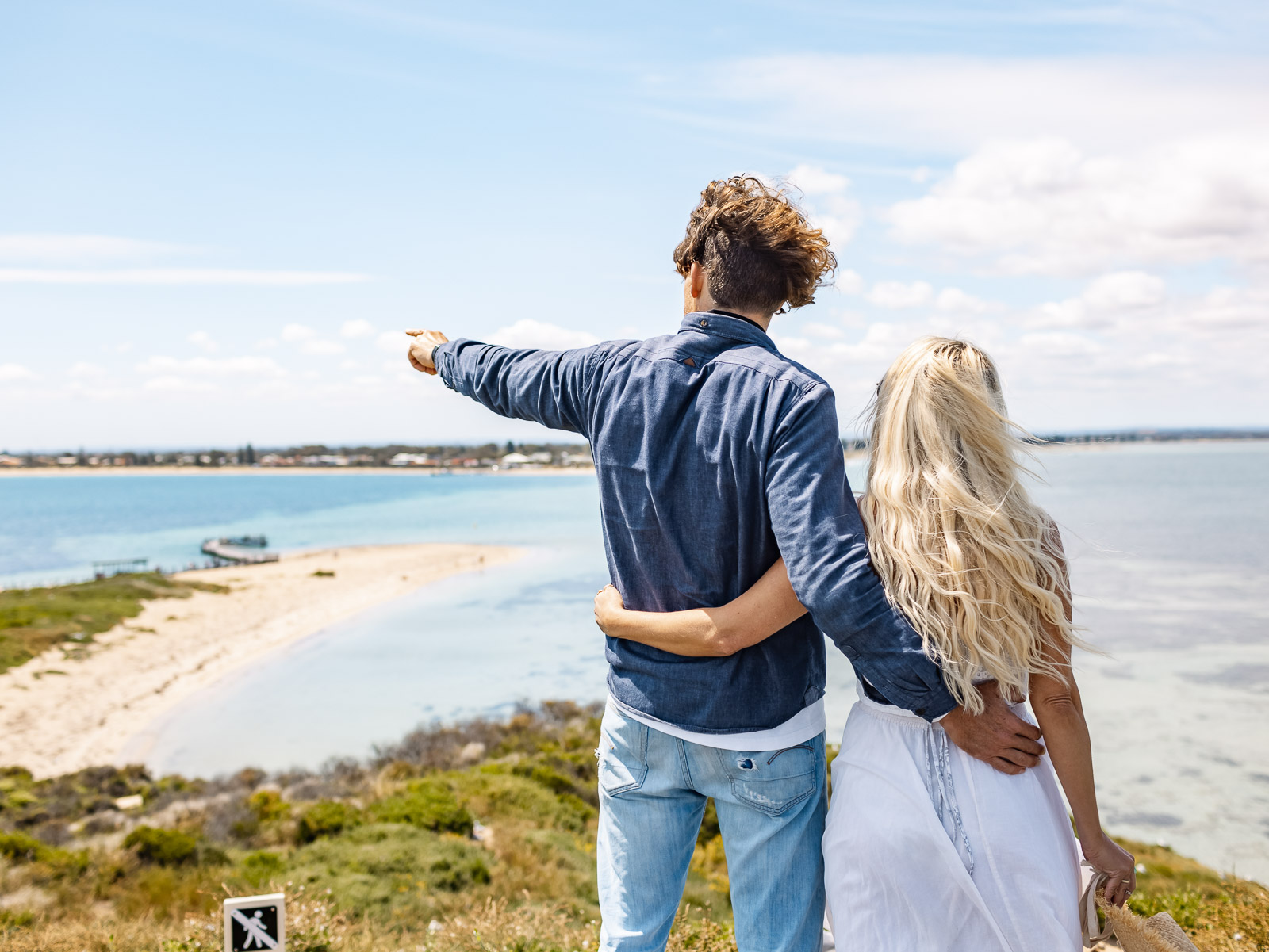 A couple stands by Margaret River’s scenic seaside as the man points at the ocean, ready for a thrilling wildlife adventure.