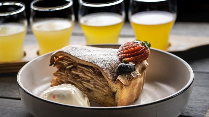 Delicious slice of apple pie topped with creamy ice cream and fresh berries, paired with drinks on Huon Valley Safaris Private Tour.