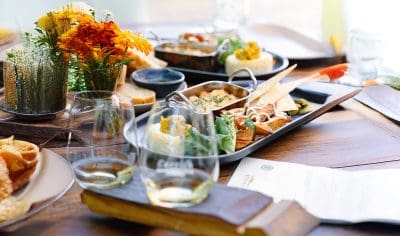 An inviting table displays gourmet appetisers, elegant wine glasses, and fresh flowers—perfect for a Boutique Wine Tour experience.