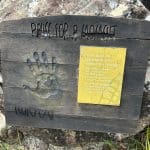 Hook Island cultural legacy sign: wooden board with handprint, engraved lettering, yellow plaque highlighting island heritage.