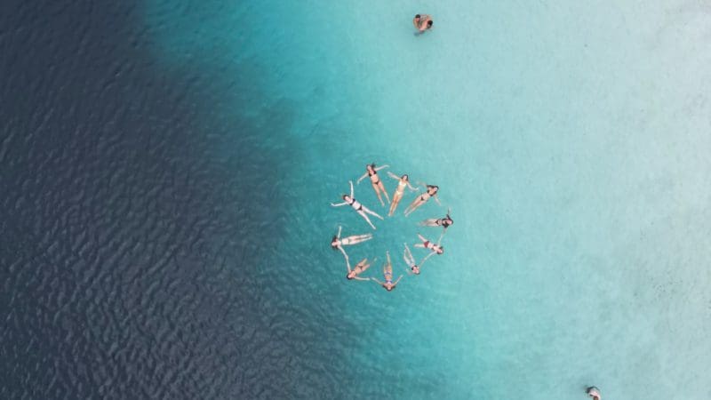 Stunning aerial shot of swimmers enjoying crystal-clear blue waters, capturing the essence of a Kgari 2 Day Tour Noosa-to-Noosa adventure.