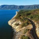 Scenic winding coastal road hugging the rocky Daintree shoreline, ideal for a private exclusive Cape Tribulation tour experience.