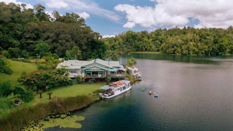 Exclusive lakeside house in Atherton Tablelands with boats, kayaks, and private tours, surrounded by lush green rainforest views.