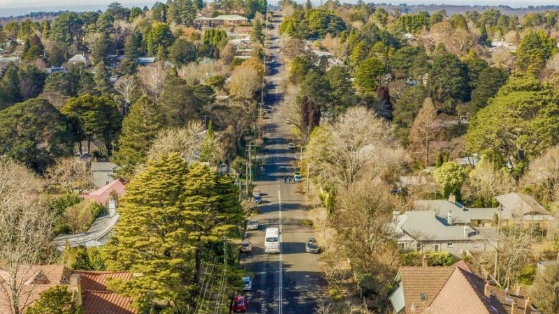 A peaceful, tree-lined suburban street extends into the distance, offering tranquillity reminiscent of a Blue Mountains sunset tour.