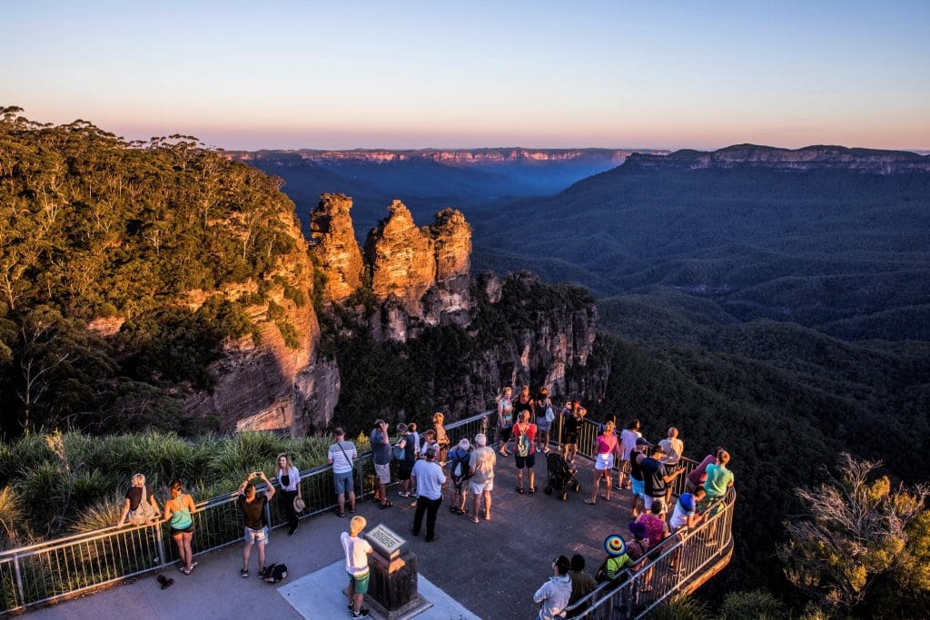Travellers marvel at the iconic Three Sisters formation at sunset from a Blue Mountains lookout on a top-rated 1 Day Wilderness Tour.