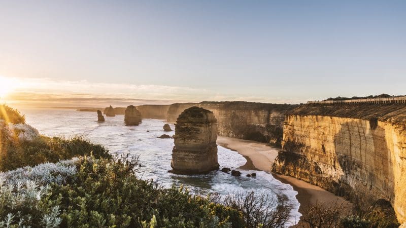 Breathtaking sunrise over the Twelve Apostles cliffs, waves crashing below on a top-rated Great Ocean Road tour from Melbourne.