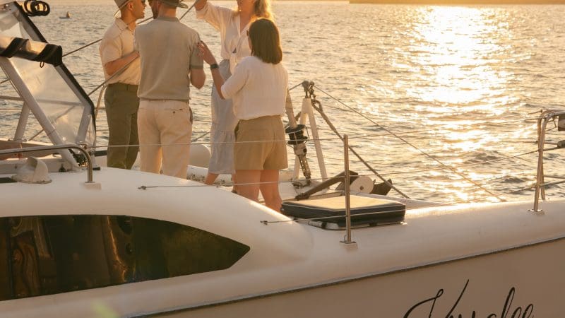 Group of friends toasting drinks at sunset on Kirralee catamaran cruise, Sydney Harbour, BYO Sparkle tour, stunning city views.