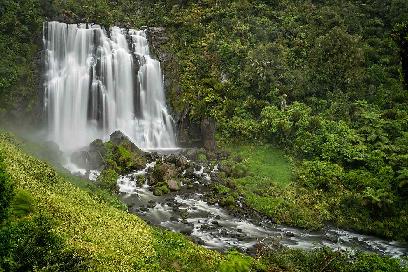 waterfalls cascading down lush green forrest