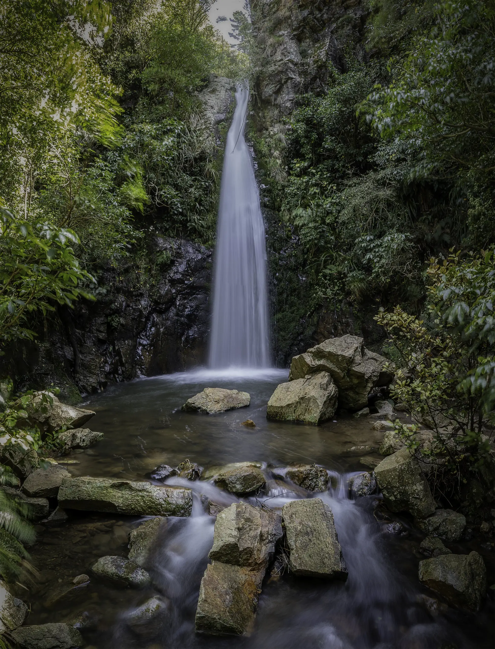 Long drop waterfall between rocks and trees