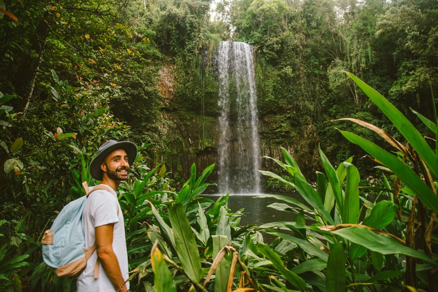 man with backpack near millaa millaa falls cairns